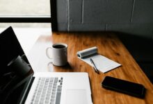 مكتب عليه حاسوب وأوراق لمراجعة نص