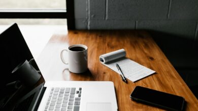 مكتب عليه حاسوب وأوراق لمراجعة نص